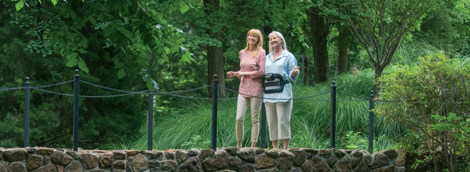 Woman wearing spinalStim device on a bridge
